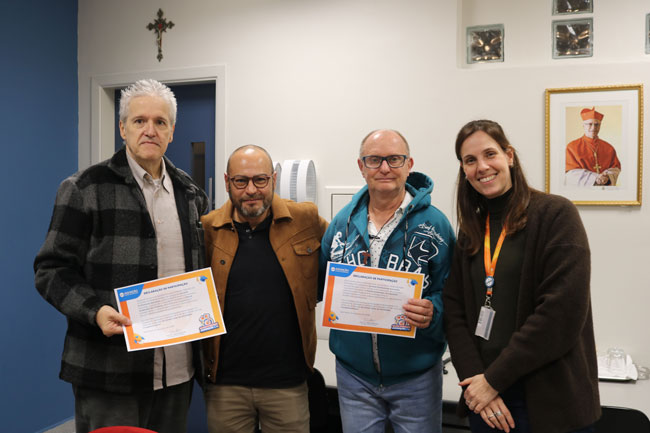 Prof. Dr. Sidnei Ferreira de Vares e Prof.ª Dr.ª Luciana Savoi Rossi entregam certificados a alunos do curso vencedor
