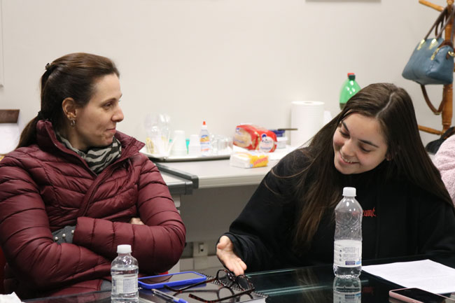 Prof.ª Dr.ª Luciana Savoi Rossi ao lado da estudante Denise Silva de Oliveira, que destaca como o programa a ajudou a perceber que não é necessário ter domínio perfeito do inglês para se comunicar.