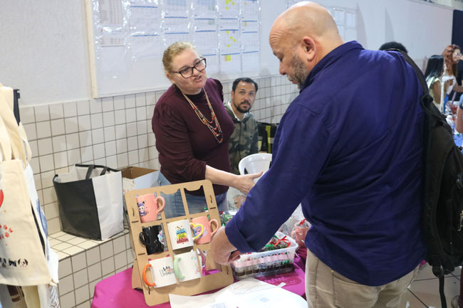 Expositora apresenta seus produtos para visitante.